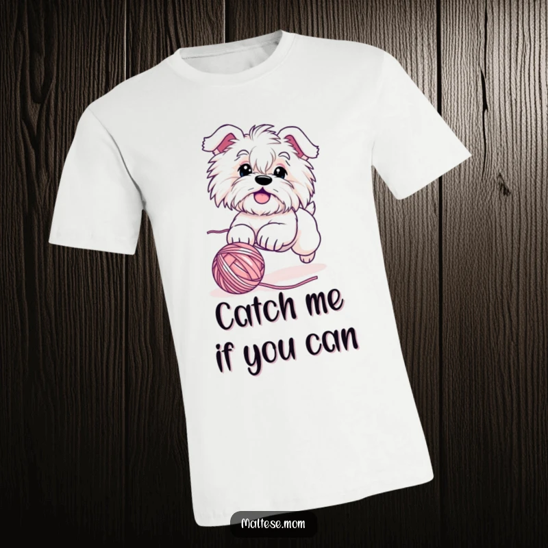 Funny Maltese dog t-shirt showcasing a cute character in dynamic motion, playfully chasing a rolling ball of yarn with boundless enthusiasm.