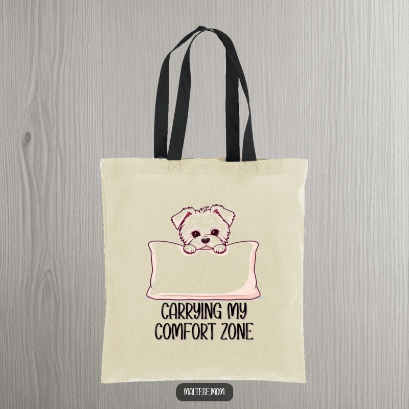 Funny Maltese puppy peeking from behind a large, soft cushion, featured on a charming and practical tote bag.